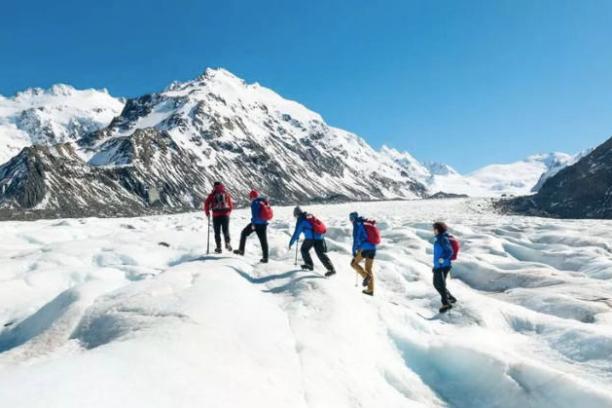 a group of people riding skis down a snow covered mountain