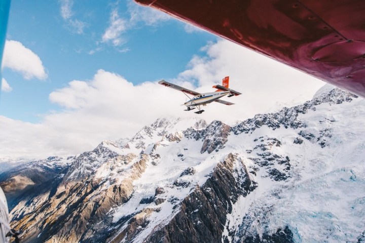 a person flying through the air on a snow covered mountain