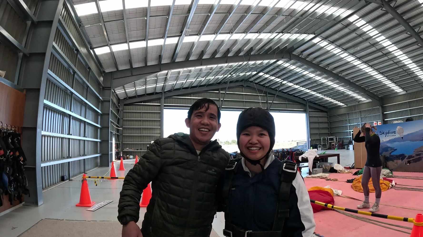 People hugging in skydive hangar in front of door